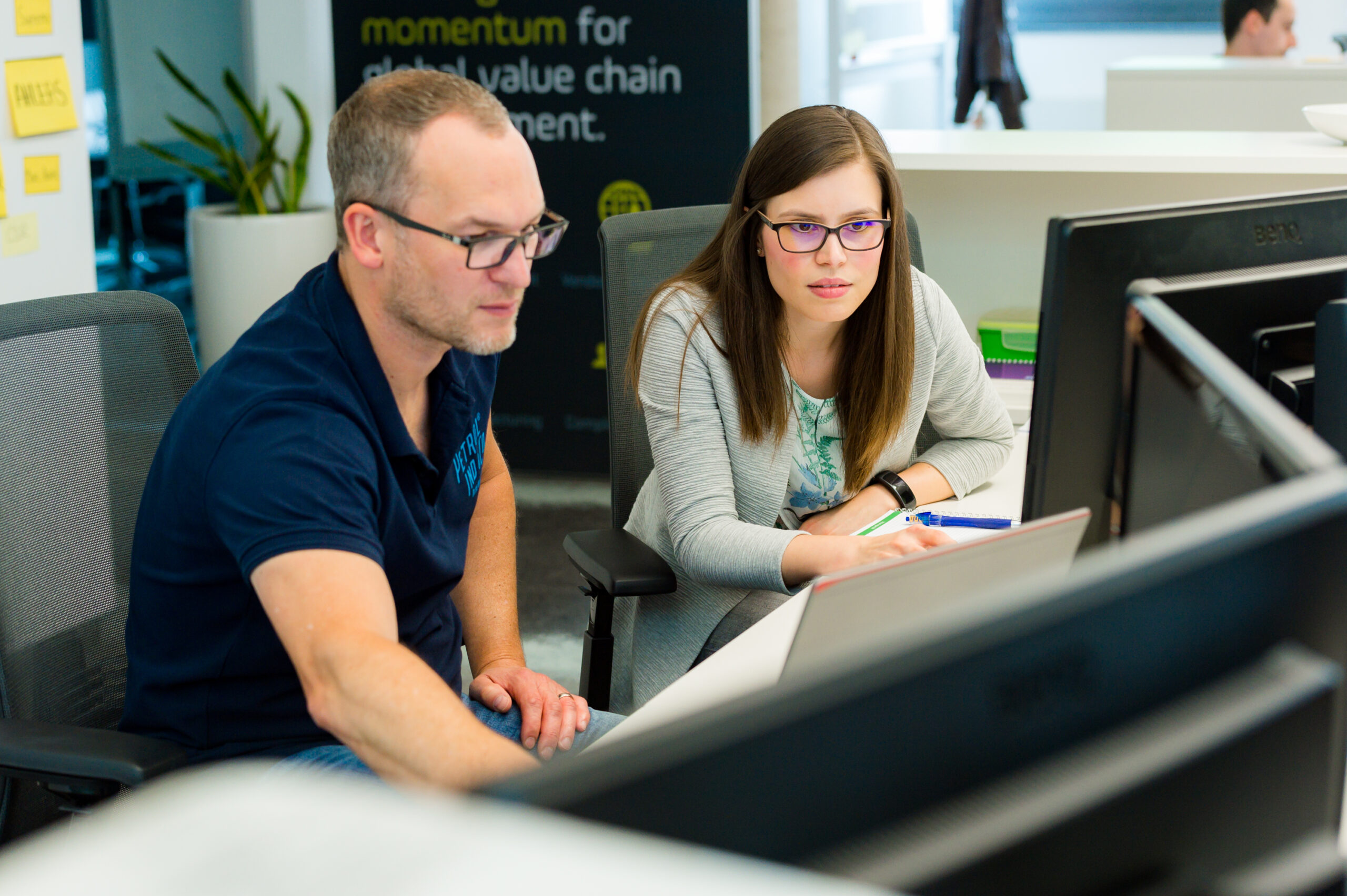 two Setlog employees working on OSCA supply chain management software